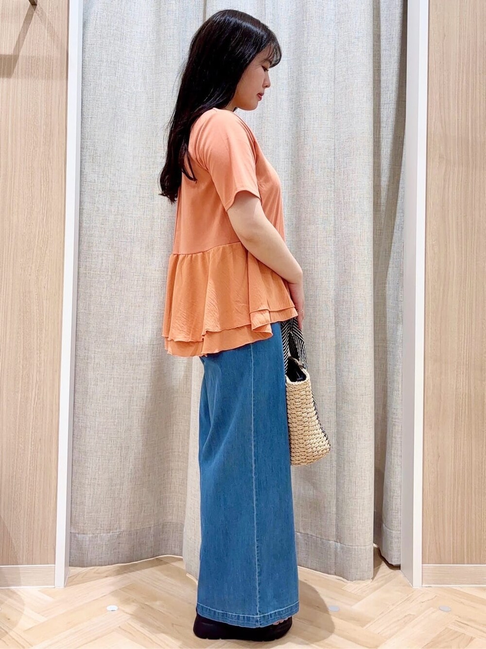 オレンジ系のTシャツ/カットソー、ベージュ系のトートバッグ、その他のネックレスを着用したレディースの夏コーディネートの2枚目の写真