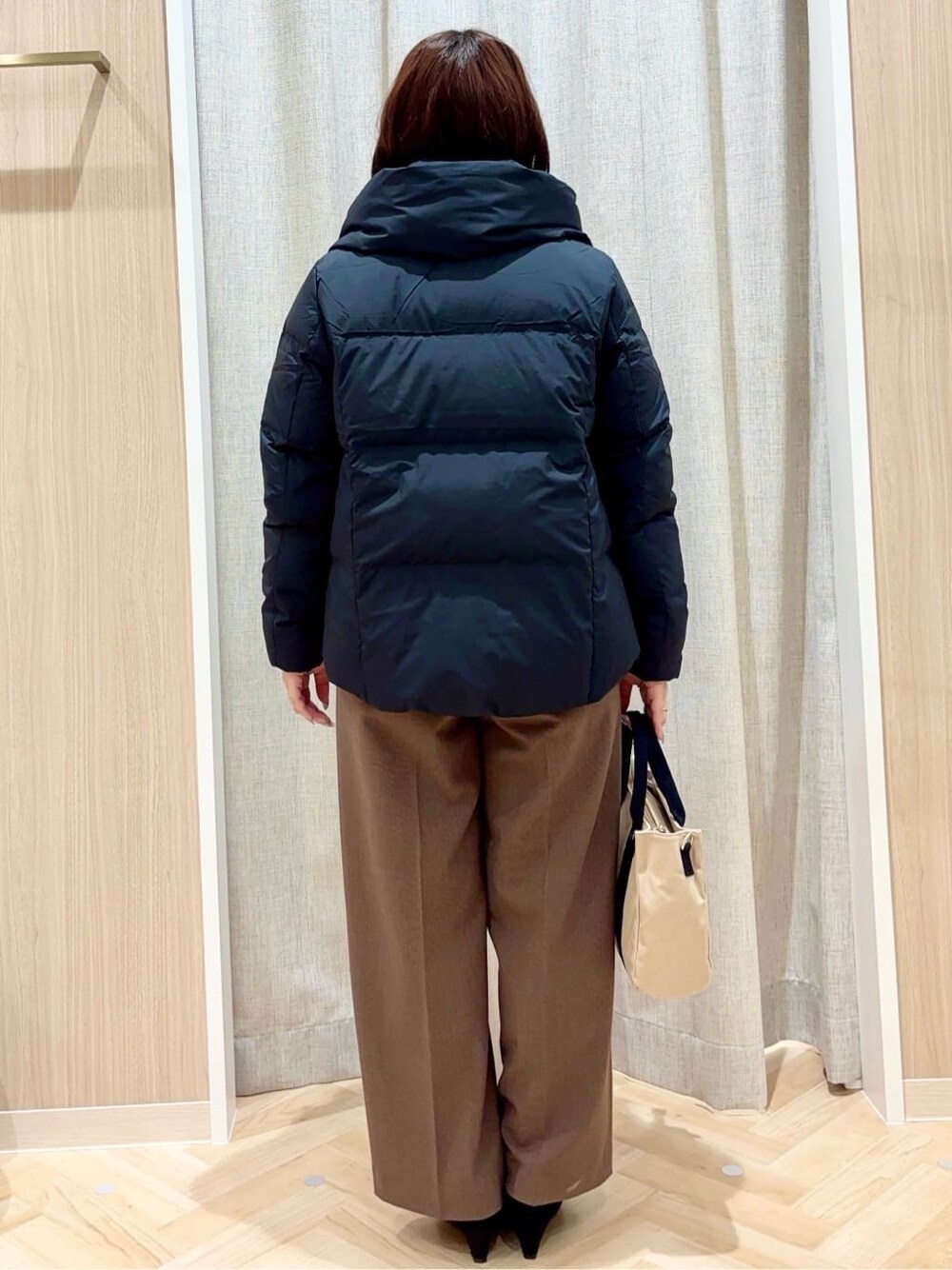 ブラック系のトートバッグ、ブラック系のパンプスを着用したレディースの冬コーディネートの3枚目の写真