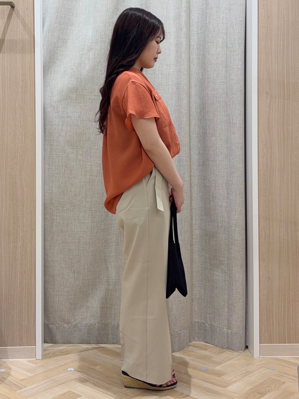 ベージュ系のその他パンツ、ブラック系のトートバッグ、ピンク系のネックレスを着用したレディースの夏コーディネートの2枚目の写真
