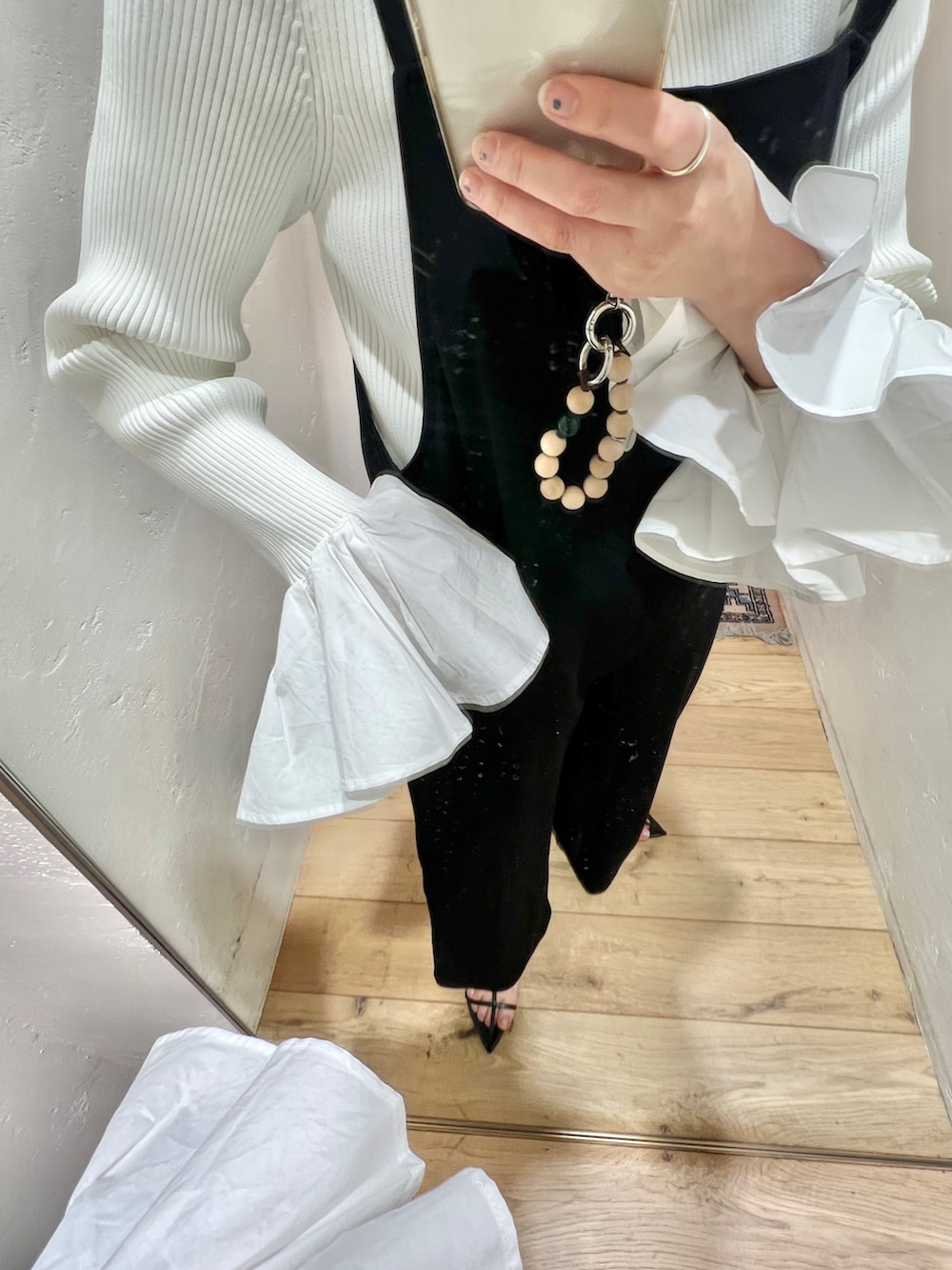 ホワイト系のニット/セーター、ブラック系のサロペット/オーバーオール、ベージュ系のノーカラージャケットを着用したレディースの春コーディネートの2枚目の写真