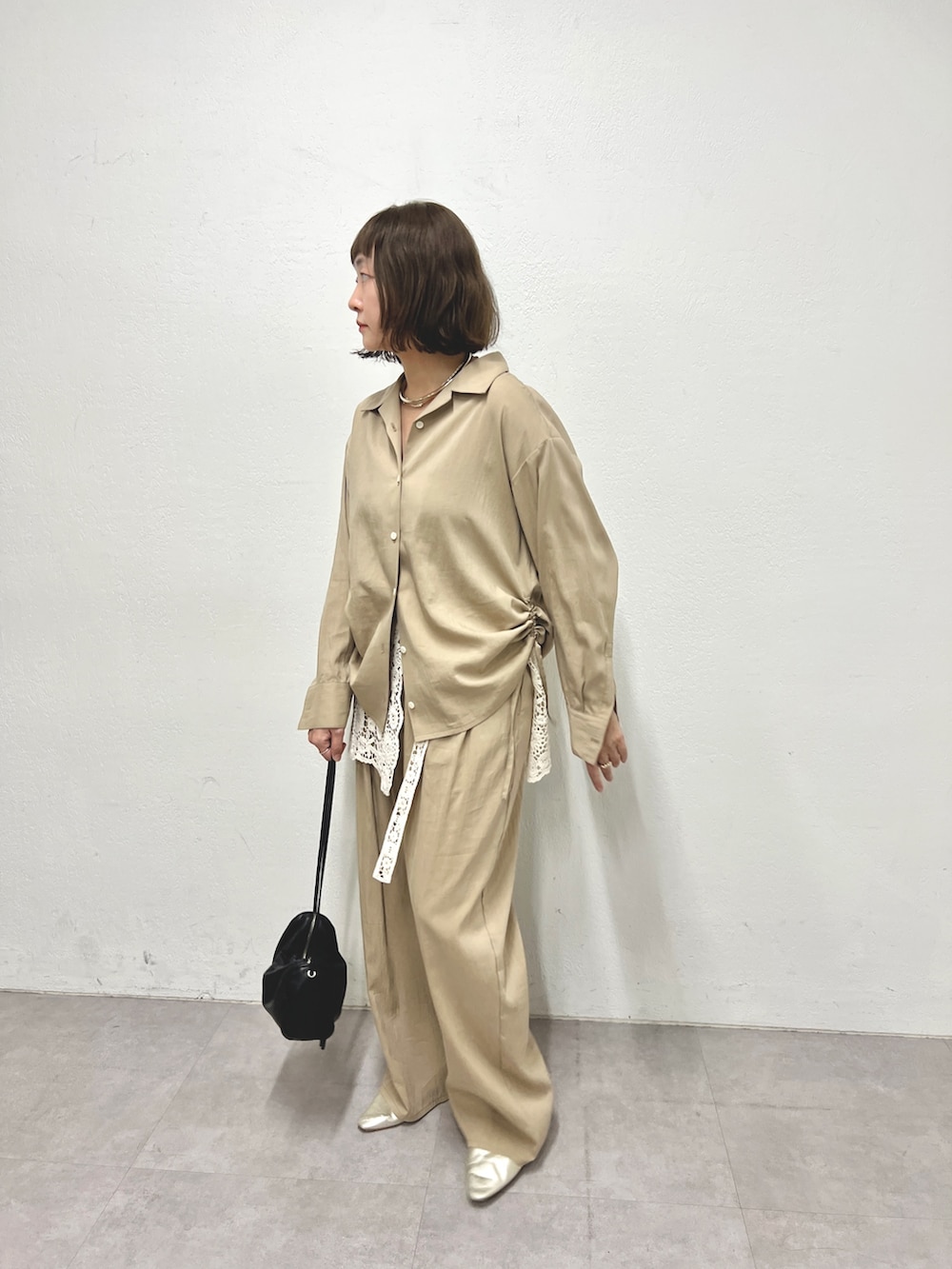 ベージュ系のシャツ/ブラウス、ベージュ系のその他パンツ、ホワイト系のストール/ショールを着用したレディースの冬コーディネートの2枚目の写真