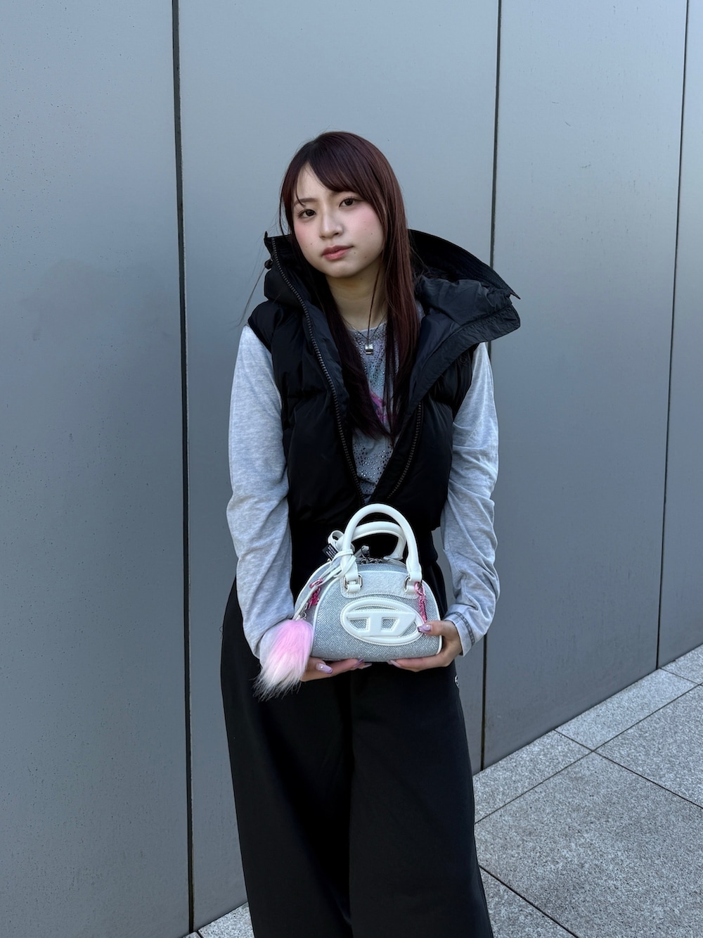 ブラック系のダウンベスト、グレー系のTシャツ/カットソー、ブラック系のスウェットパンツを着用したレディースの冬コーディネートの2枚目の写真