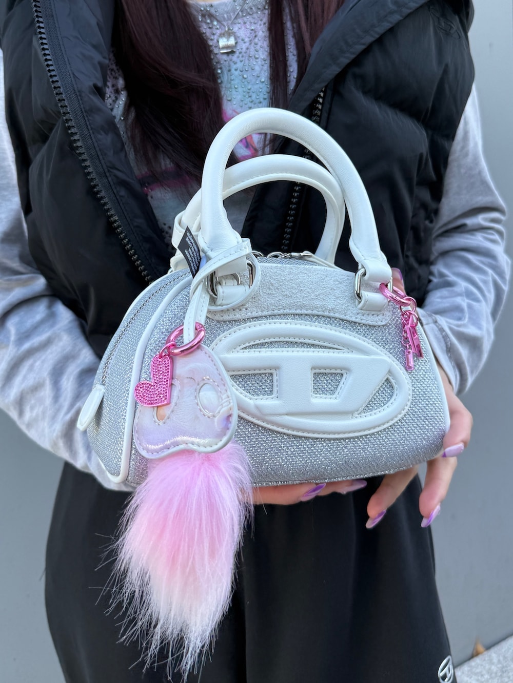 ブラック系のダウンベスト、グレー系のTシャツ/カットソー、ブラック系のスウェットパンツを着用したレディースの冬コーディネートの4枚目の写真