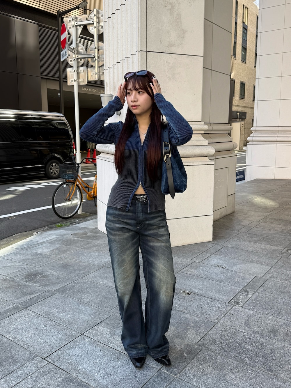 ブラック系のカーディガン/ボレロ、ブルー系のデニムパンツ、ブルー系のショルダーバッグを着用したレディースの秋コーディネートの2枚目の写真