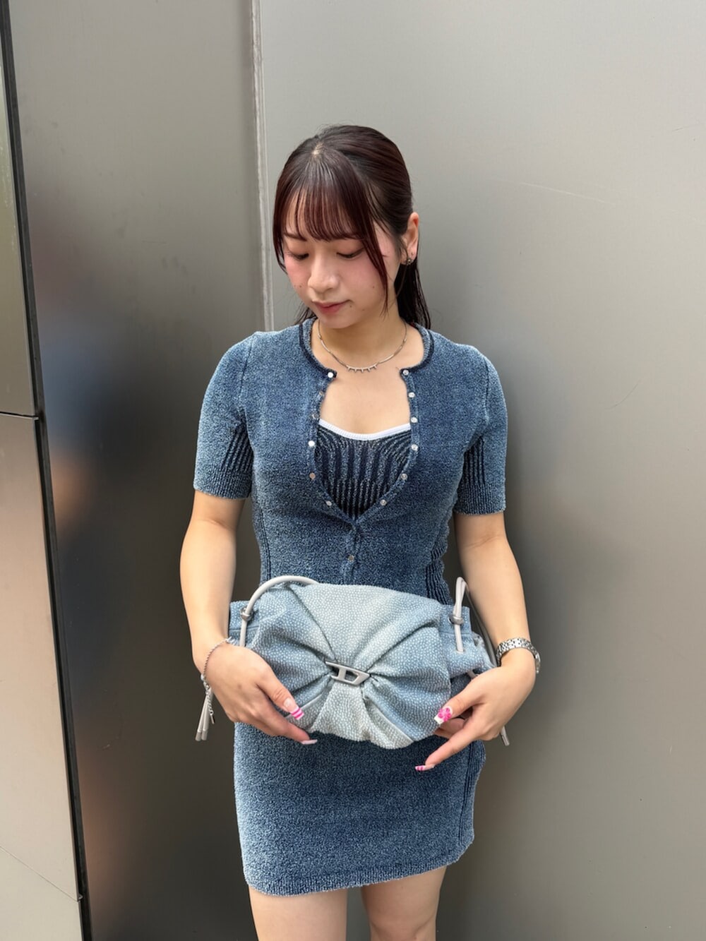 ブラック系のブーツ、ブルー系のショルダーバッグ、その他のネックレスを着用したレディースの夏コーディネートの2枚目の写真