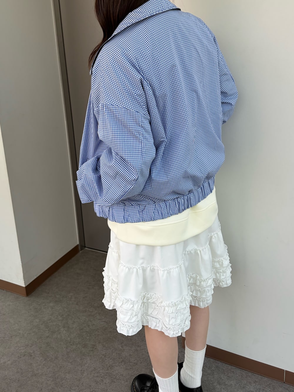 ホワイト系のスウェット、ブルー系のブルゾン、ホワイト系のスカートを着用したレディースの冬コーディネートの6枚目の写真