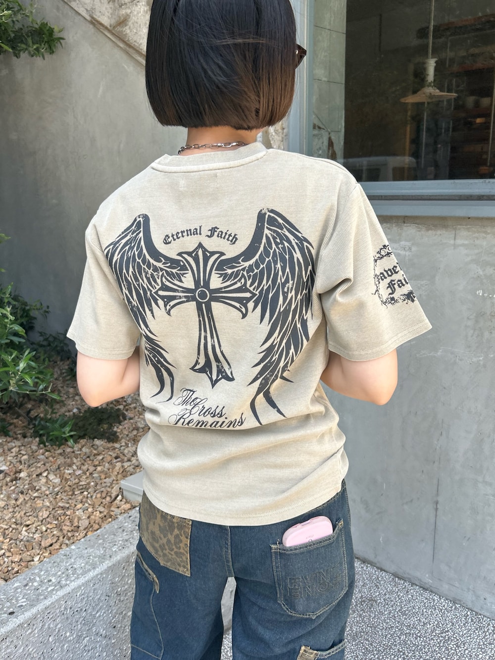 ベージュ系のTシャツ/カットソー、ブルー系のデニムパンツ、グレー系のスニーカーを着用したレディースの夏コーディネートの2枚目の写真