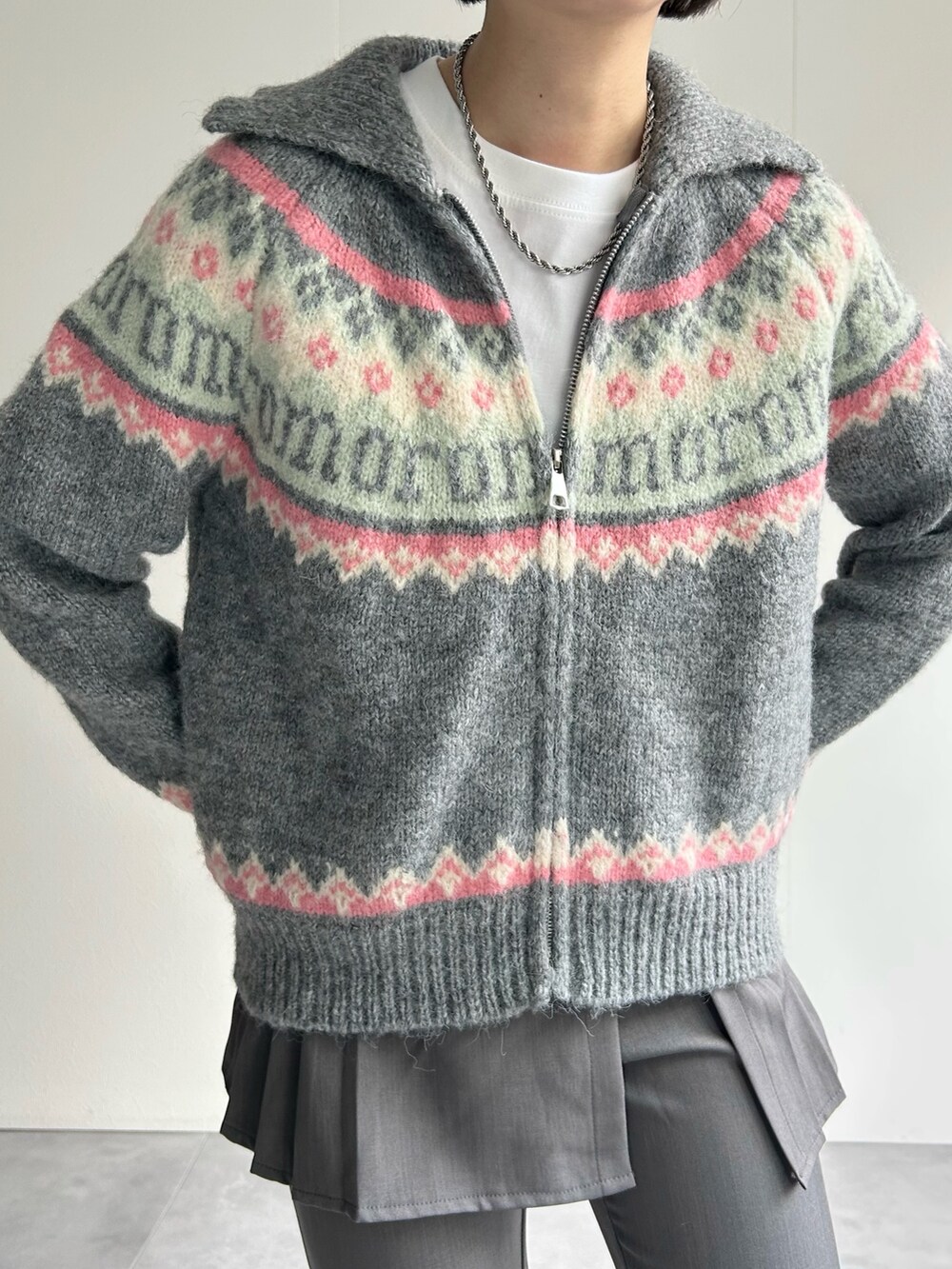 グレー系のニット/セーター、グレー系のその他パンツ、ピンク系のハンドバッグを着用したレディースの秋コーディネートの2枚目の写真