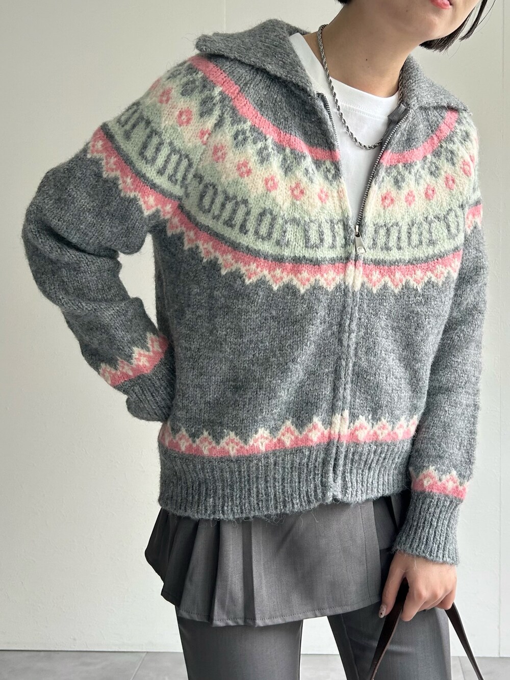 グレー系のニット/セーター、グレー系のその他パンツ、ピンク系のハンドバッグを着用したレディースの秋コーディネートの3枚目の写真