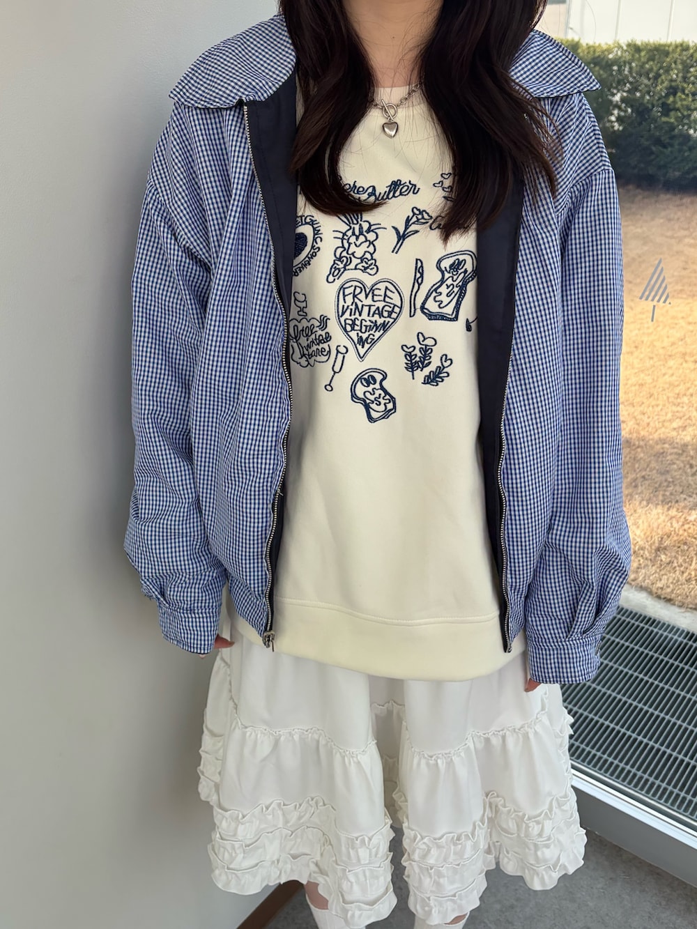 ホワイト系のスウェット、ブルー系のブルゾン、ホワイト系のスカートを着用したレディースの冬コーディネートの5枚目の写真