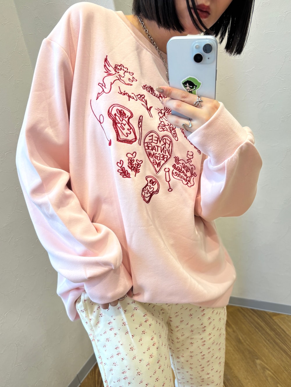 ピンク系のスウェット、ベージュ系のスリッポン、ホワイト系のスウェットパンツを着用したレディースの冬コーディネートの3枚目の写真