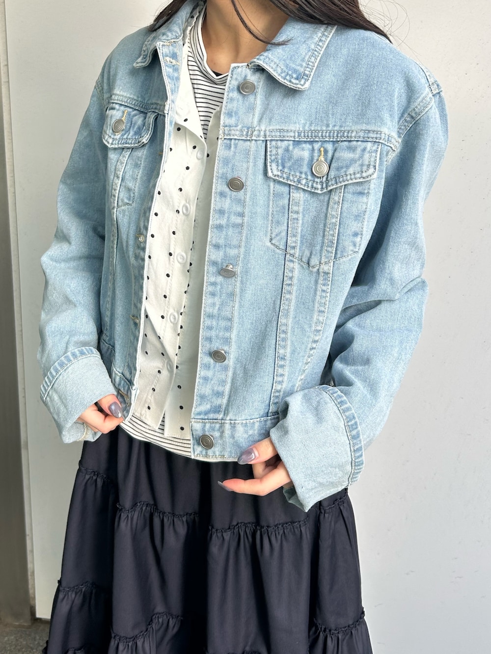 ブルー系のデニムジャケット、ブルー系のスカート、ブラック系のドレスシューズを着用したレディースの春コーディネートの2枚目の写真