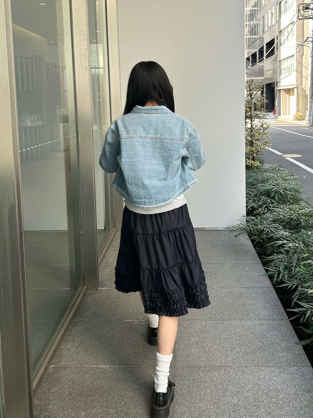 ブルー系のデニムジャケット、ブルー系のスカート、ブラック系のドレスシューズを着用したレディースの春コーディネートの3枚目の写真