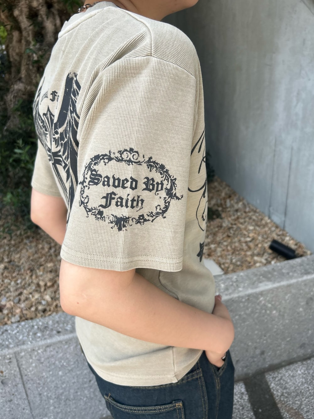 ベージュ系のTシャツ/カットソー、ブルー系のデニムパンツ、グレー系のスニーカーを着用したレディースの夏コーディネートの3枚目の写真
