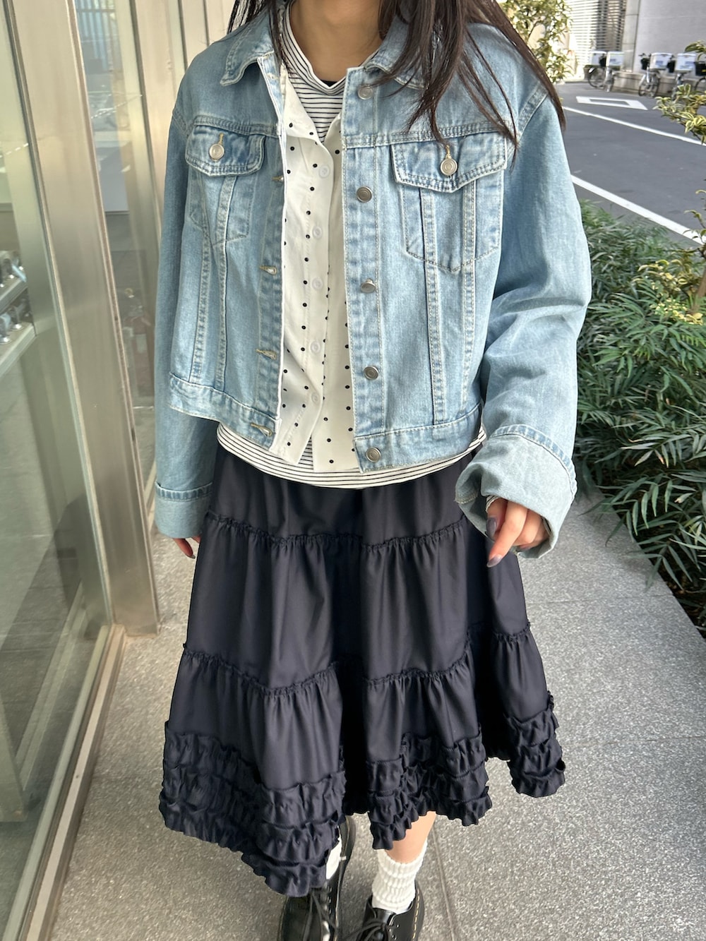 ブルー系のデニムジャケット、ブルー系のスカート、ブラック系のドレスシューズを着用したレディースの春コーディネートの4枚目の写真