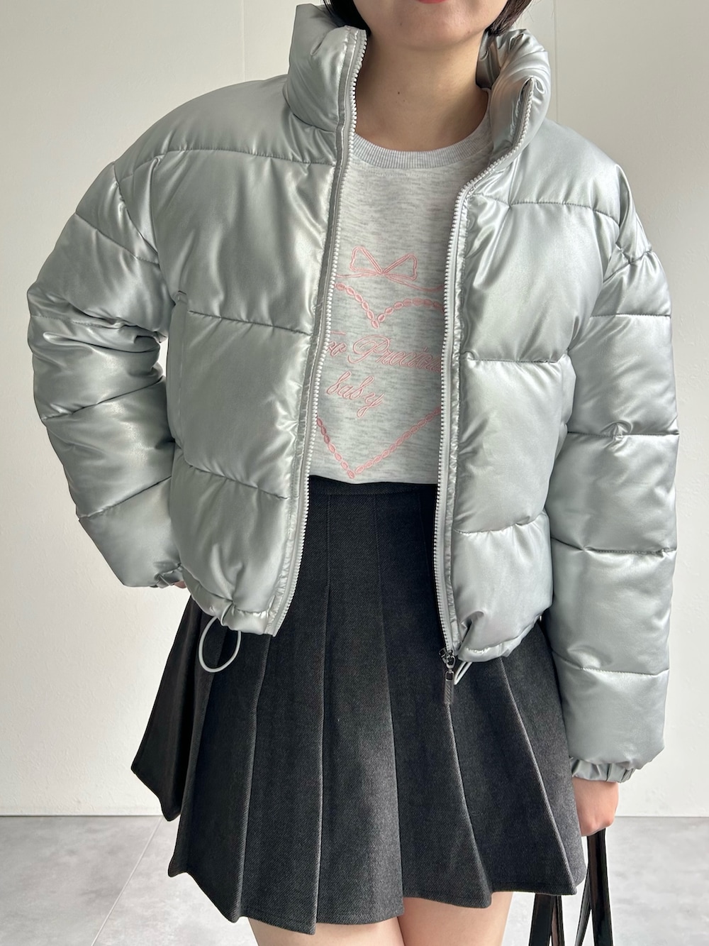 シルバー系のダウンジャケット/コート、グレー系のスカート、グレー系のスウェットを着用したレディースの秋コーディネートの5枚目の写真