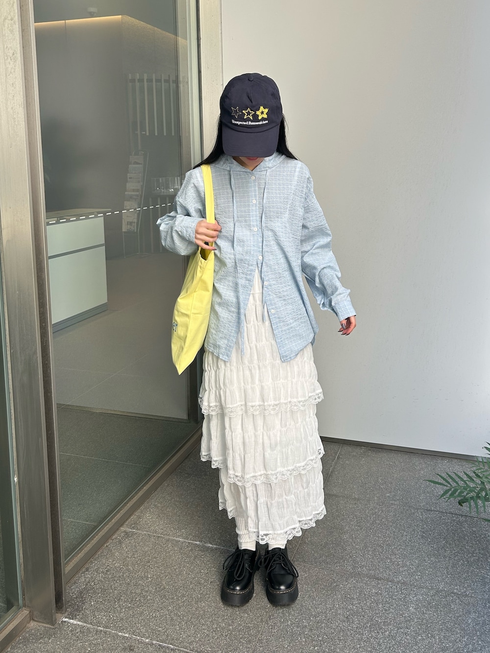 ブルー系のシャツ/ブラウス、ホワイト系のワンピース、イエロー系のトートバッグを着用したレディースの春コーディネートの4枚目の写真