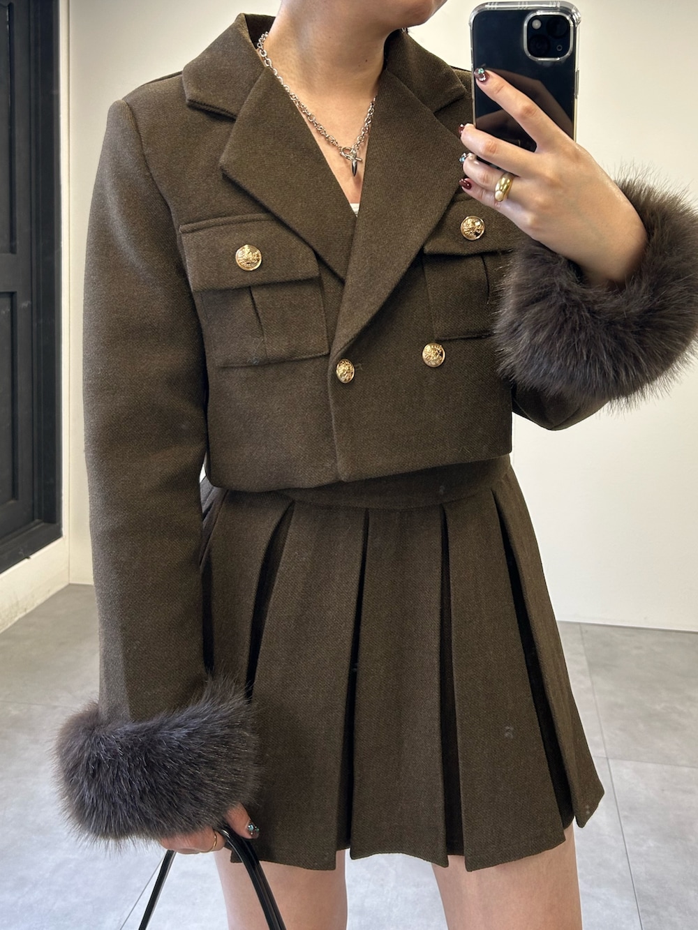 ブラウン系のセットアップを着用したレディースの冬コーディネートの2枚目の写真