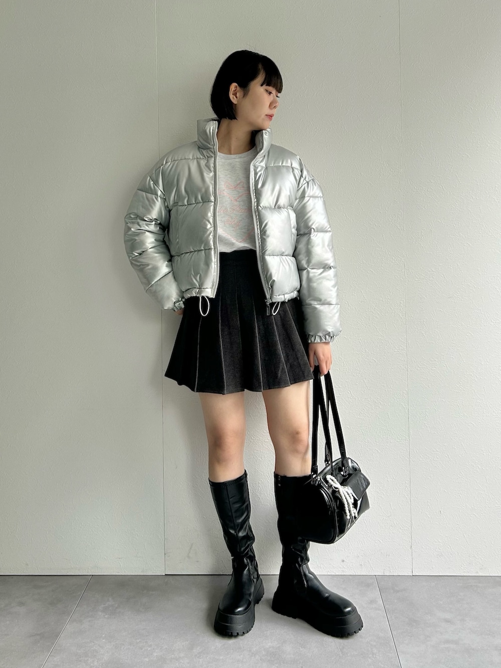 シルバー系のダウンジャケット/コート、グレー系のスカート、グレー系のスウェットを着用したレディースの秋コーディネートの2枚目の写真