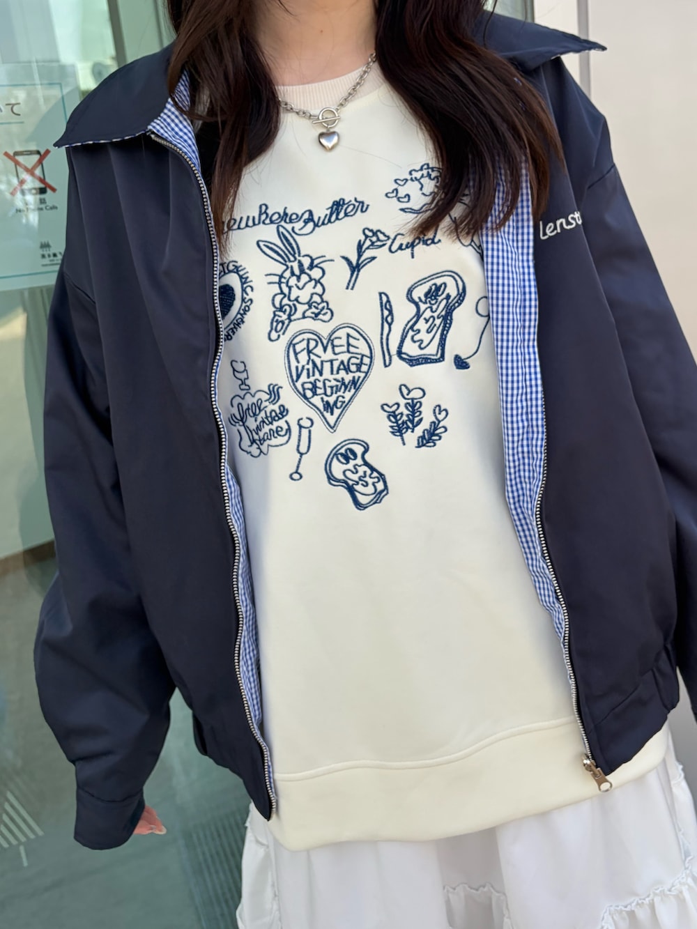 ホワイト系のスウェット、ブルー系のブルゾン、ホワイト系のスカートを着用したレディースの冬コーディネートの4枚目の写真