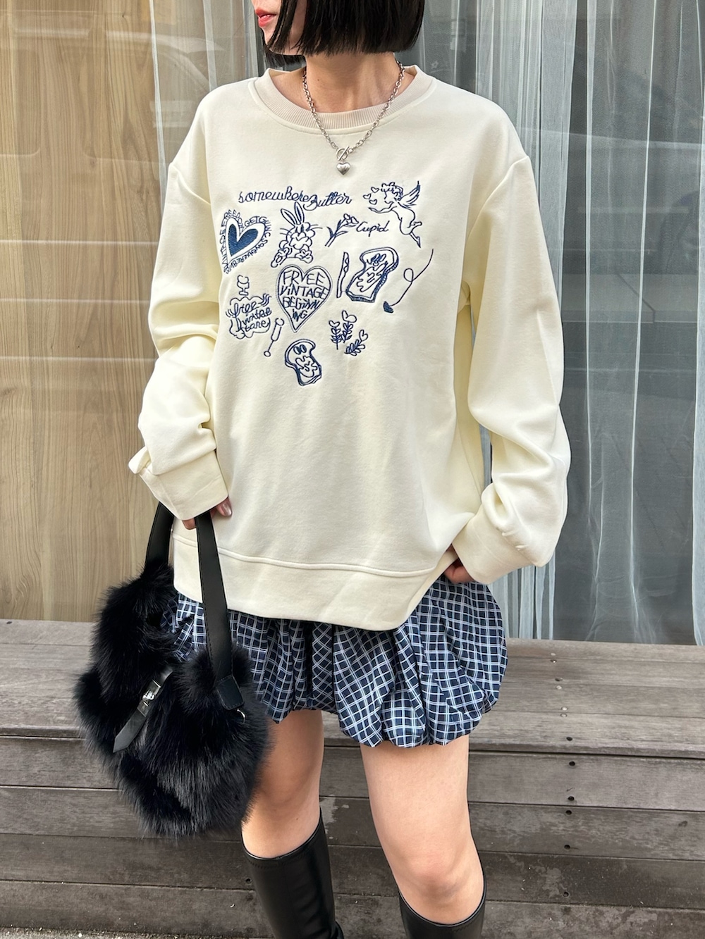 その他のスカート、ブラック系のハンドバッグ、ホワイト系のスウェットを着用したレディースの冬コーディネートの2枚目の写真