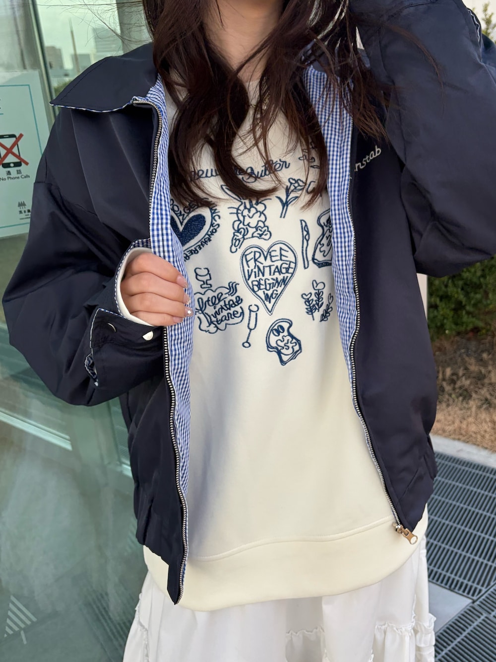 ホワイト系のスウェット、ブルー系のブルゾン、ホワイト系のスカートを着用したレディースの冬コーディネートの2枚目の写真