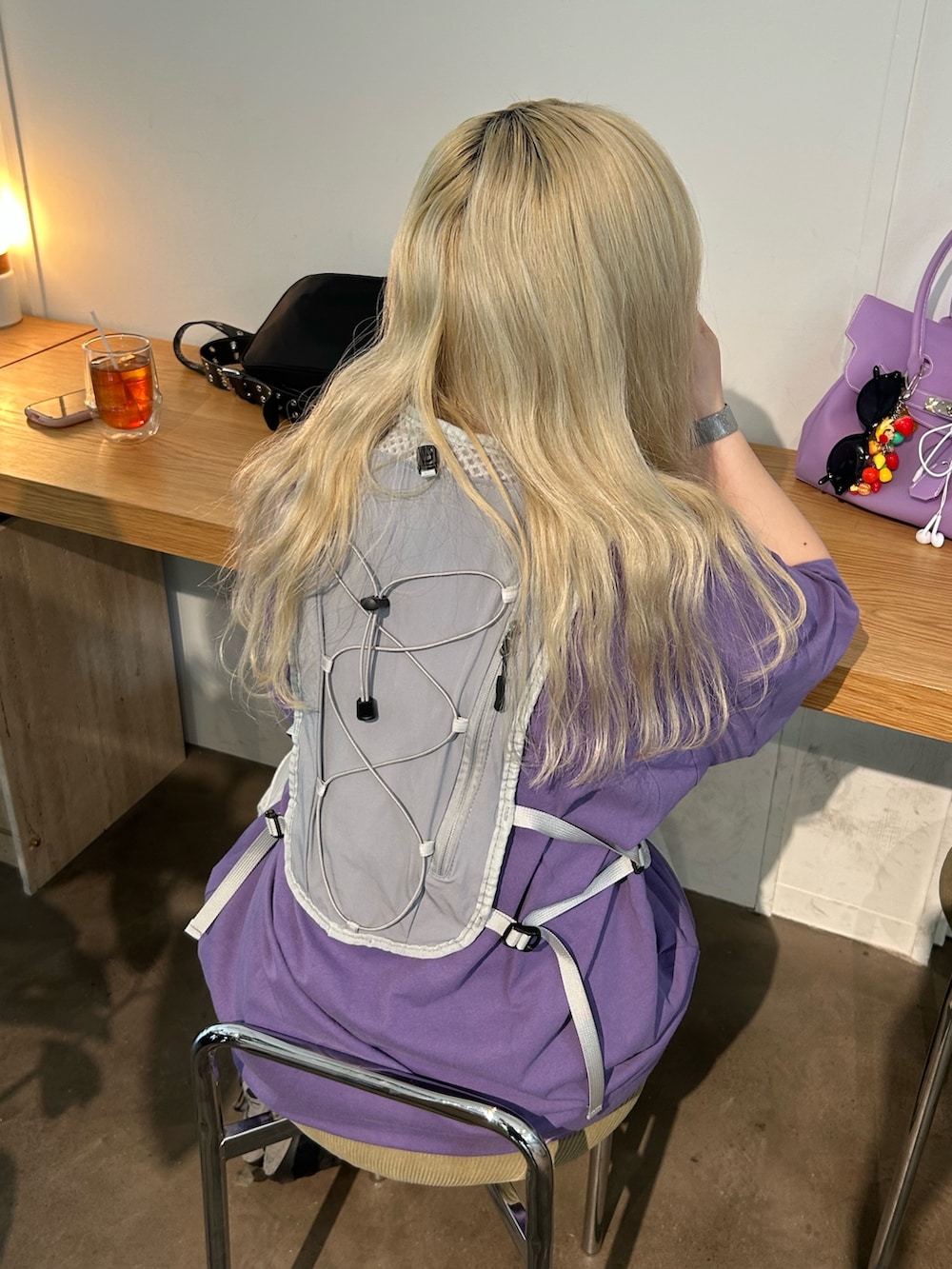 グレー系のベスト、パープル系のTシャツ/カットソー、グレー系のスニーカーを着用したレディースの夏コーディネートの3枚目の写真