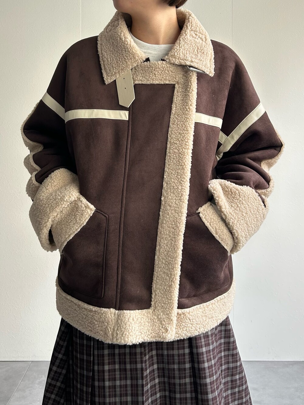 ブラウン系のムートンコート、グレー系のスウェットを着用したレディースの秋コーディネートの5枚目の写真