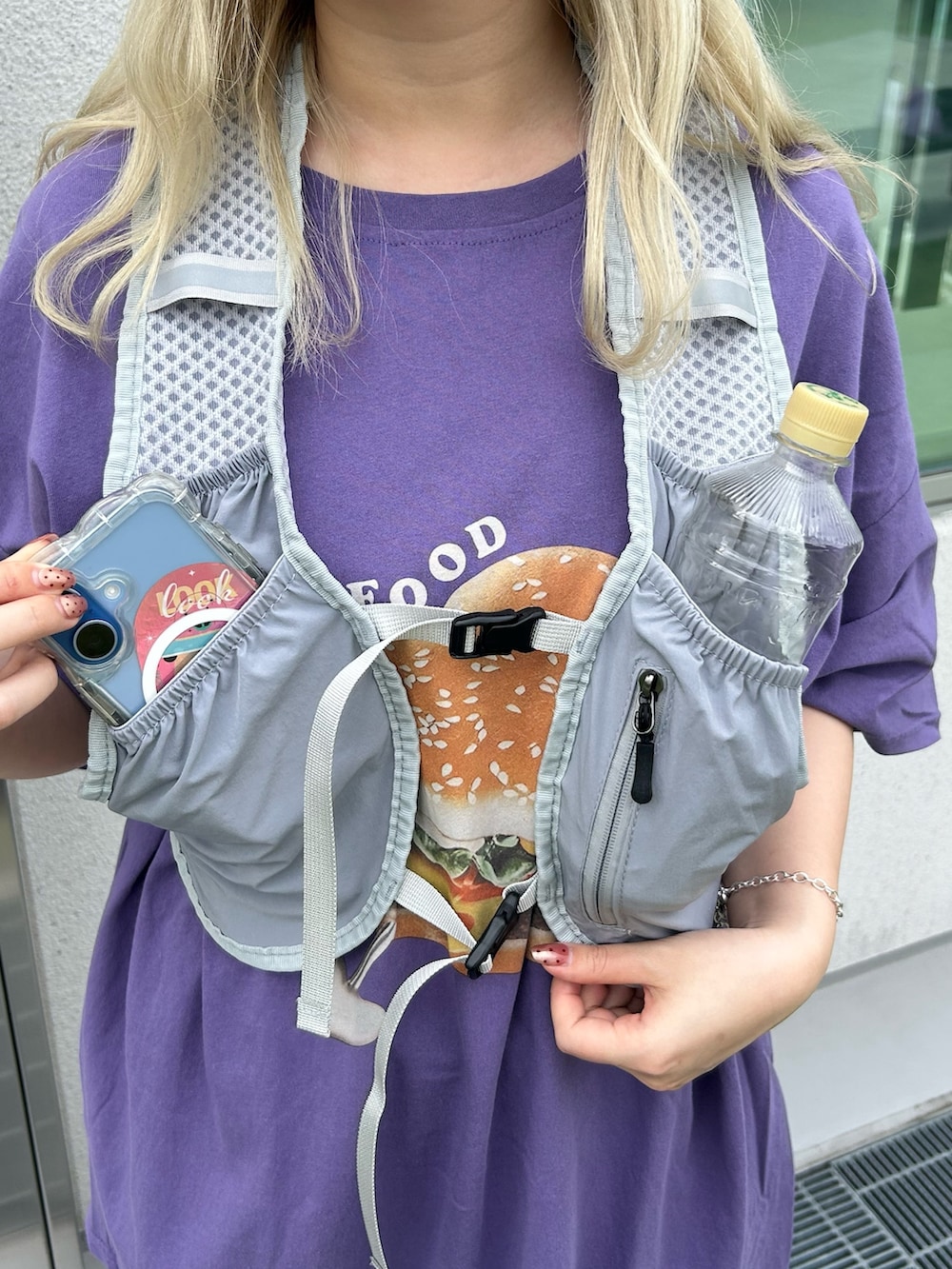 グレー系のベスト、パープル系のTシャツ/カットソー、グレー系のスニーカーを着用したレディースの夏コーディネートの4枚目の写真