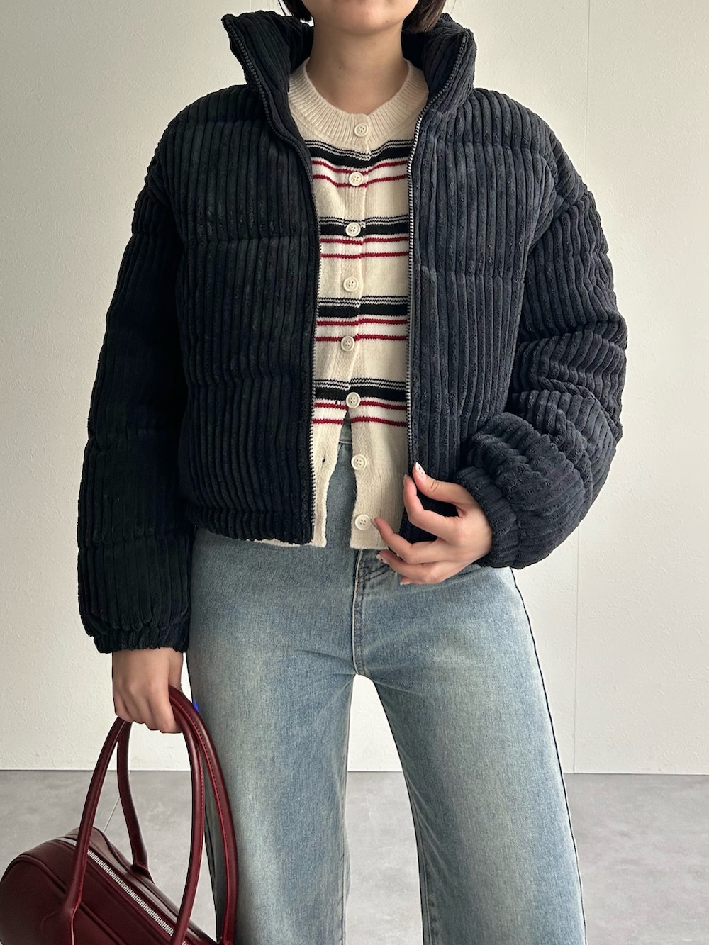 ブラック系のダウンジャケット/コート、ベージュ系のスウェット、レッド系のショルダーバッグを着用したレディースの秋コーディネートの5枚目の写真