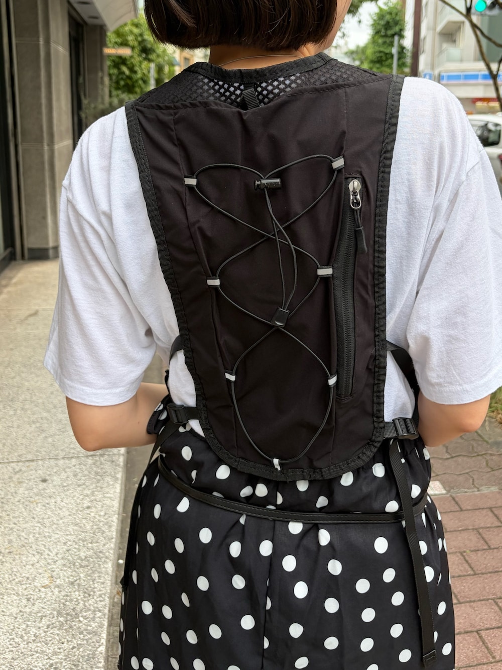 ブラック系のベスト、ブラック系のスカート、ブラック系のサングラスを着用したレディースの夏コーディネートの3枚目の写真