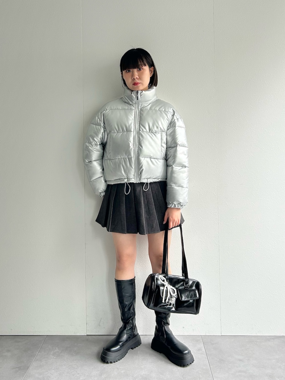 シルバー系のダウンジャケット/コート、グレー系のスカート、グレー系のスウェットを着用したレディースの秋コーディネートの3枚目の写真
