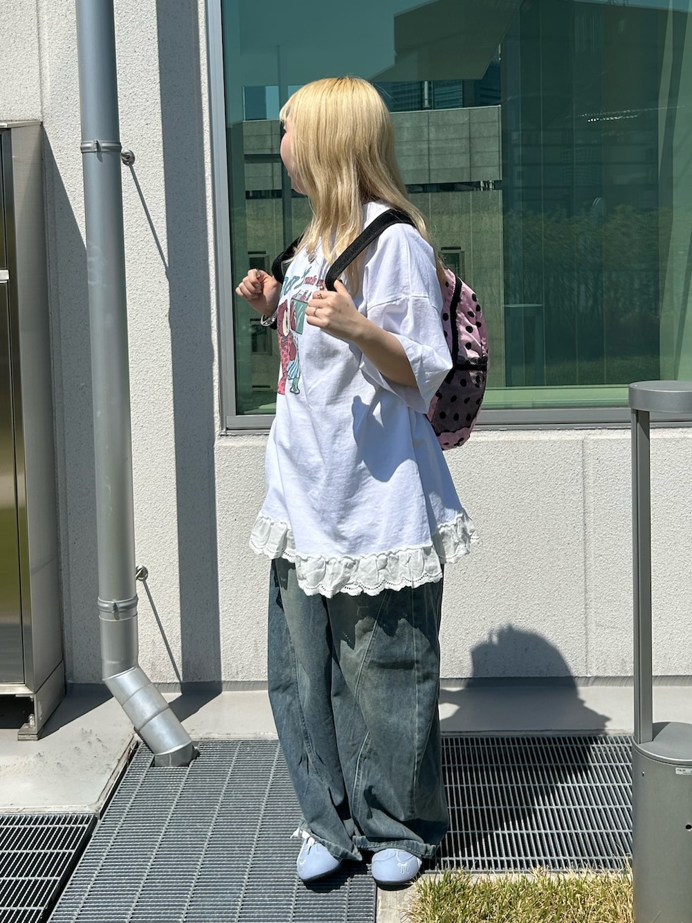 ホワイト系のTシャツ/カットソー、ブルー系のデニムパンツ、ピンク系のバックパック/リュックを着用したレディースの春コーディネートの2枚目の写真
