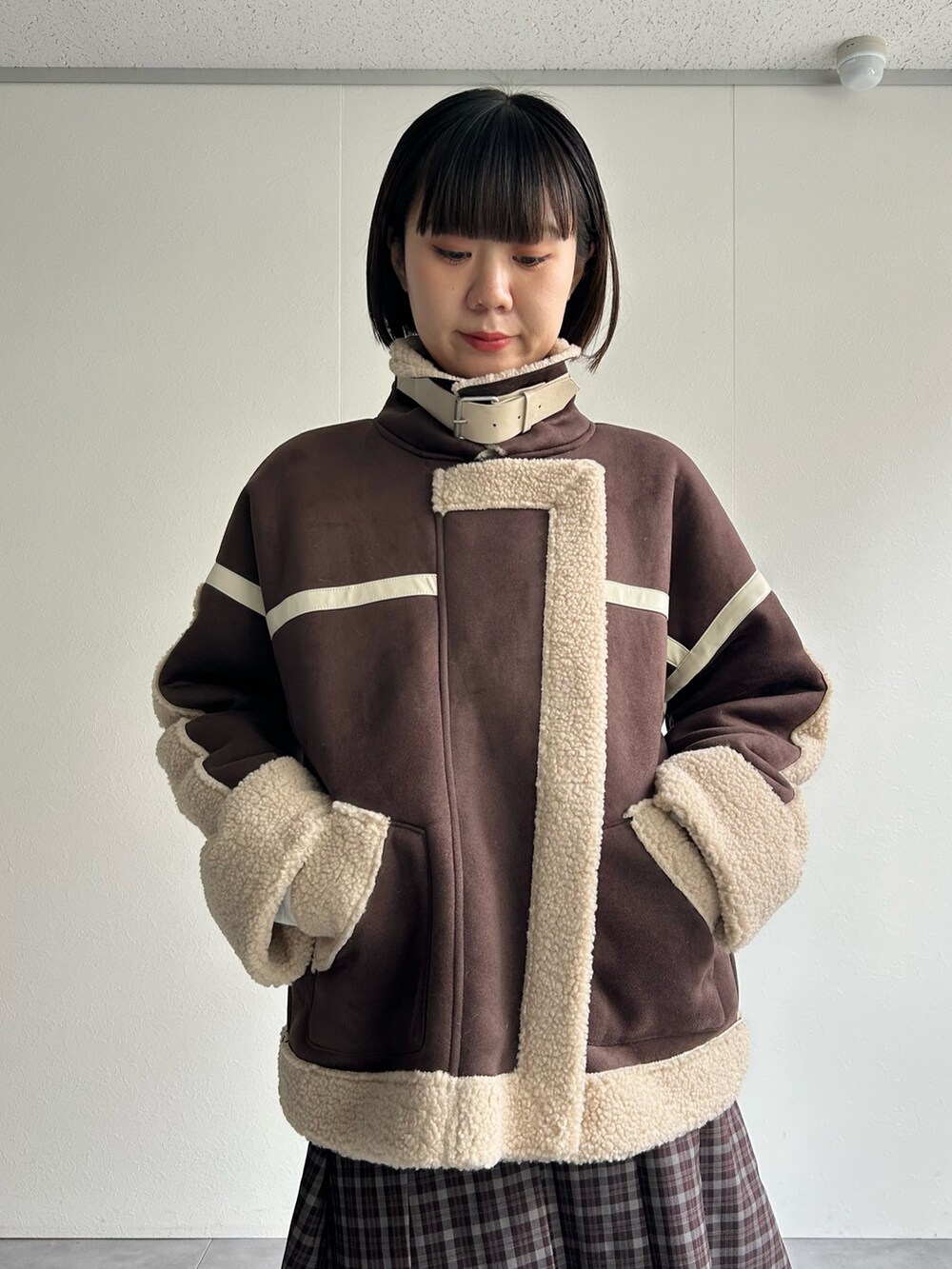 ブラウン系のムートンコート、グレー系のスウェットを着用したレディースの秋コーディネートの6枚目の写真