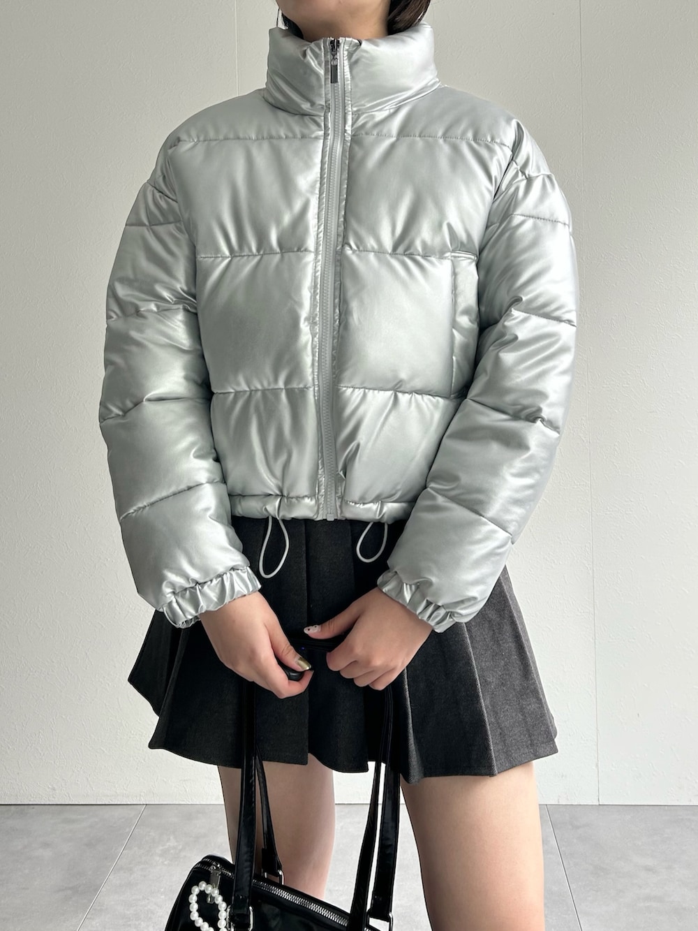 シルバー系のダウンジャケット/コート、グレー系のスカート、グレー系のスウェットを着用したレディースの秋コーディネートの6枚目の写真