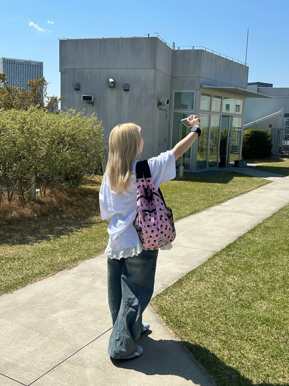 ホワイト系のTシャツ/カットソー、ブルー系のデニムパンツ、ピンク系のバックパック/リュックを着用したレディースの春コーディネートの5枚目の写真