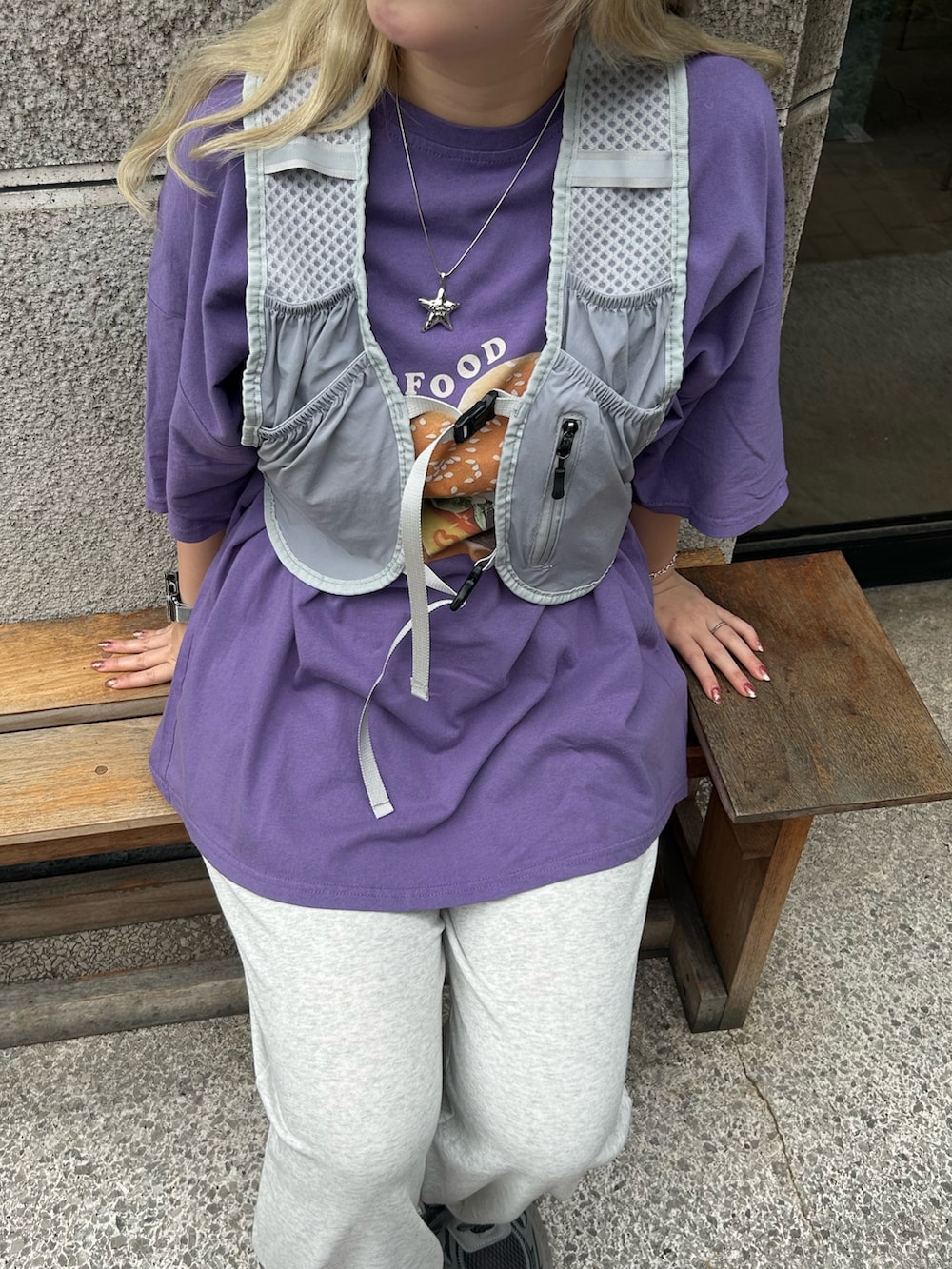グレー系のベスト、パープル系のTシャツ/カットソー、グレー系のスニーカーを着用したレディースの夏コーディネートの2枚目の写真