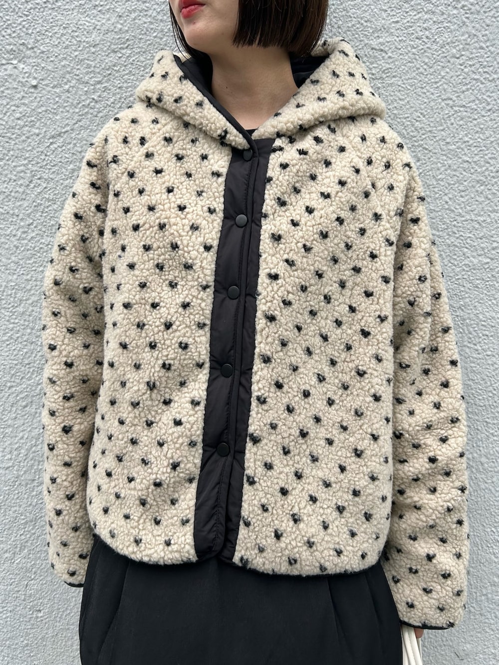 ベージュ系のブルゾン、ブラック系のワンピースを着用したレディースの冬コーディネートの2枚目の写真