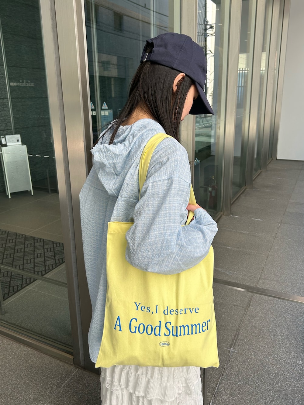 ブルー系のシャツ/ブラウス、ホワイト系のワンピース、イエロー系のトートバッグを着用したレディースの春コーディネートの3枚目の写真