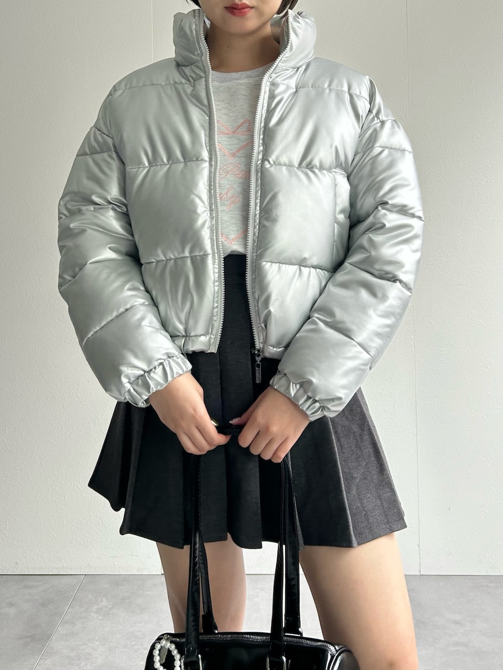 シルバー系のダウンジャケット/コート、グレー系のスカート、グレー系のスウェットを着用したレディースの秋コーディネートの4枚目の写真