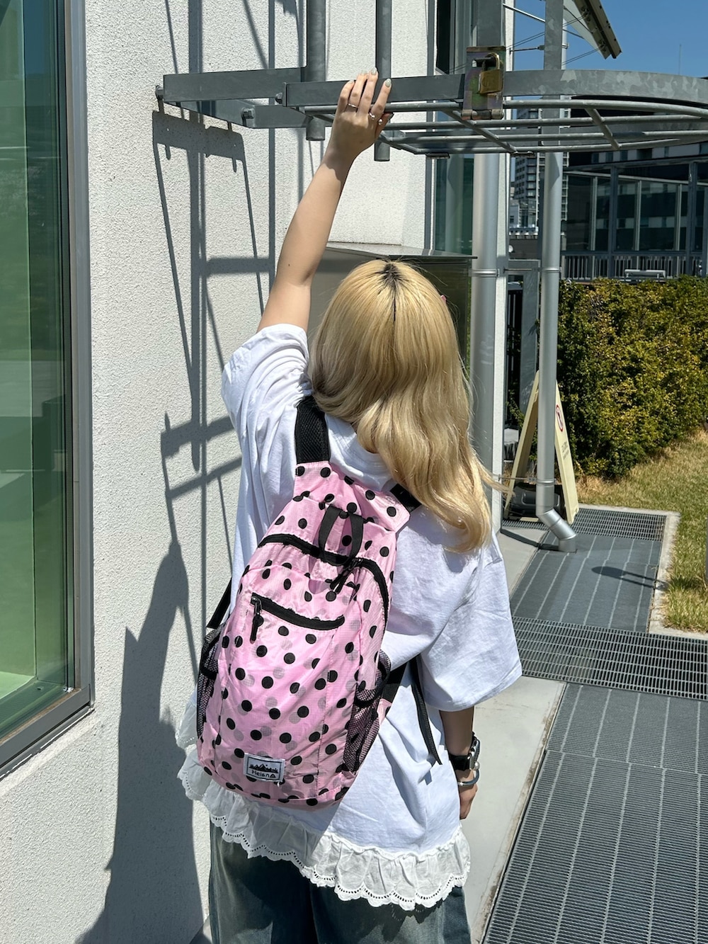 ホワイト系のTシャツ/カットソー、ブルー系のデニムパンツ、ピンク系のバックパック/リュックを着用したレディースの春コーディネートの4枚目の写真