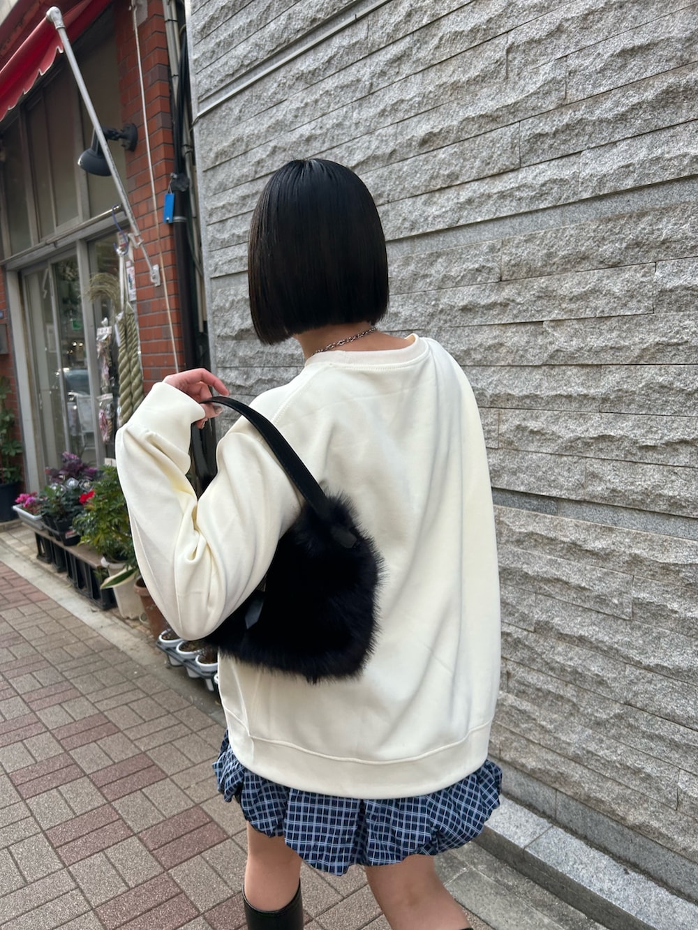 その他のスカート、ブラック系のハンドバッグ、ホワイト系のスウェットを着用したレディースの冬コーディネートの3枚目の写真