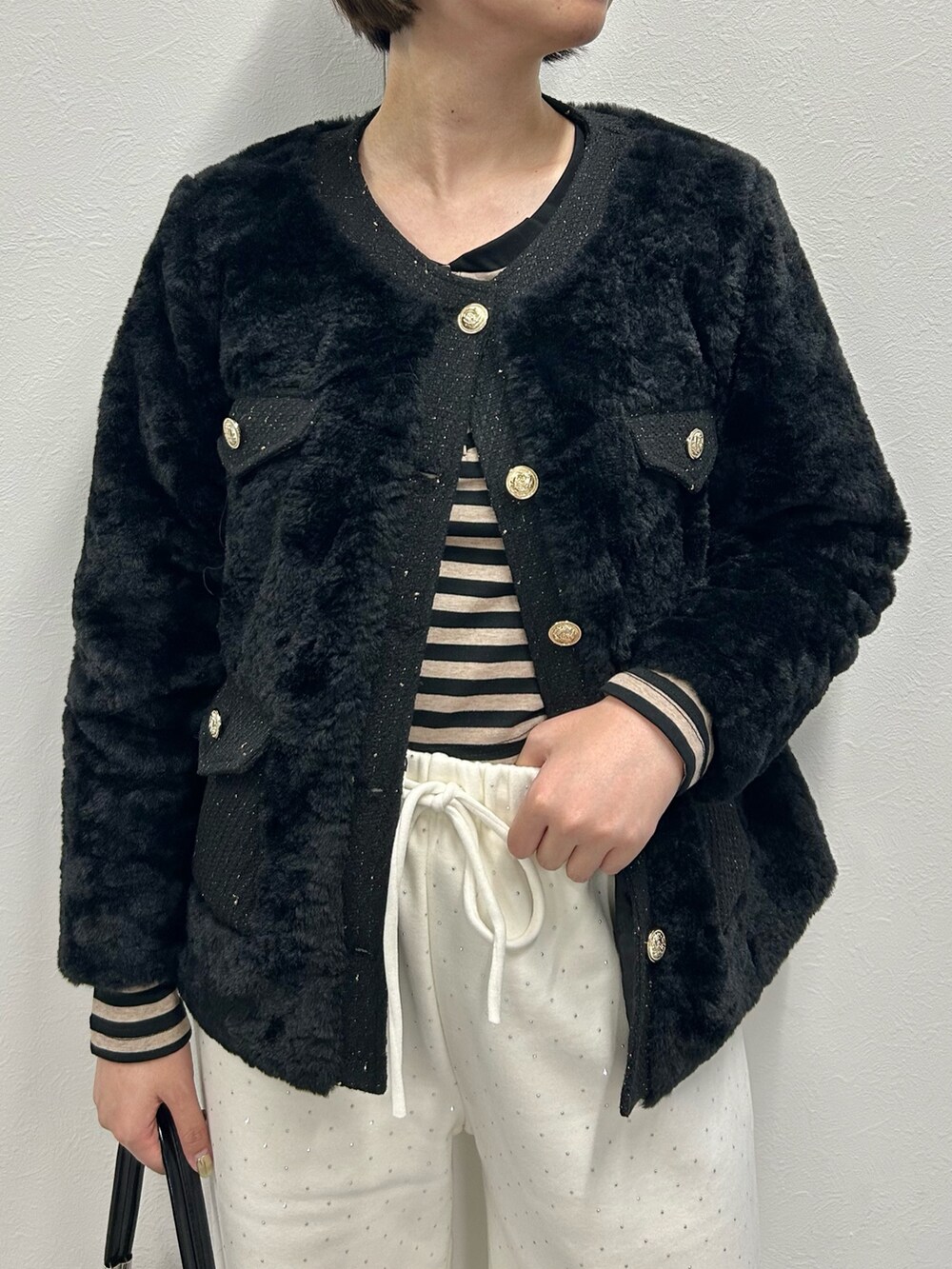 ホワイト系のノーカラージャケット、ブラック系のTシャツ/カットソーを着用したレディースの秋コーディネートの2枚目の写真