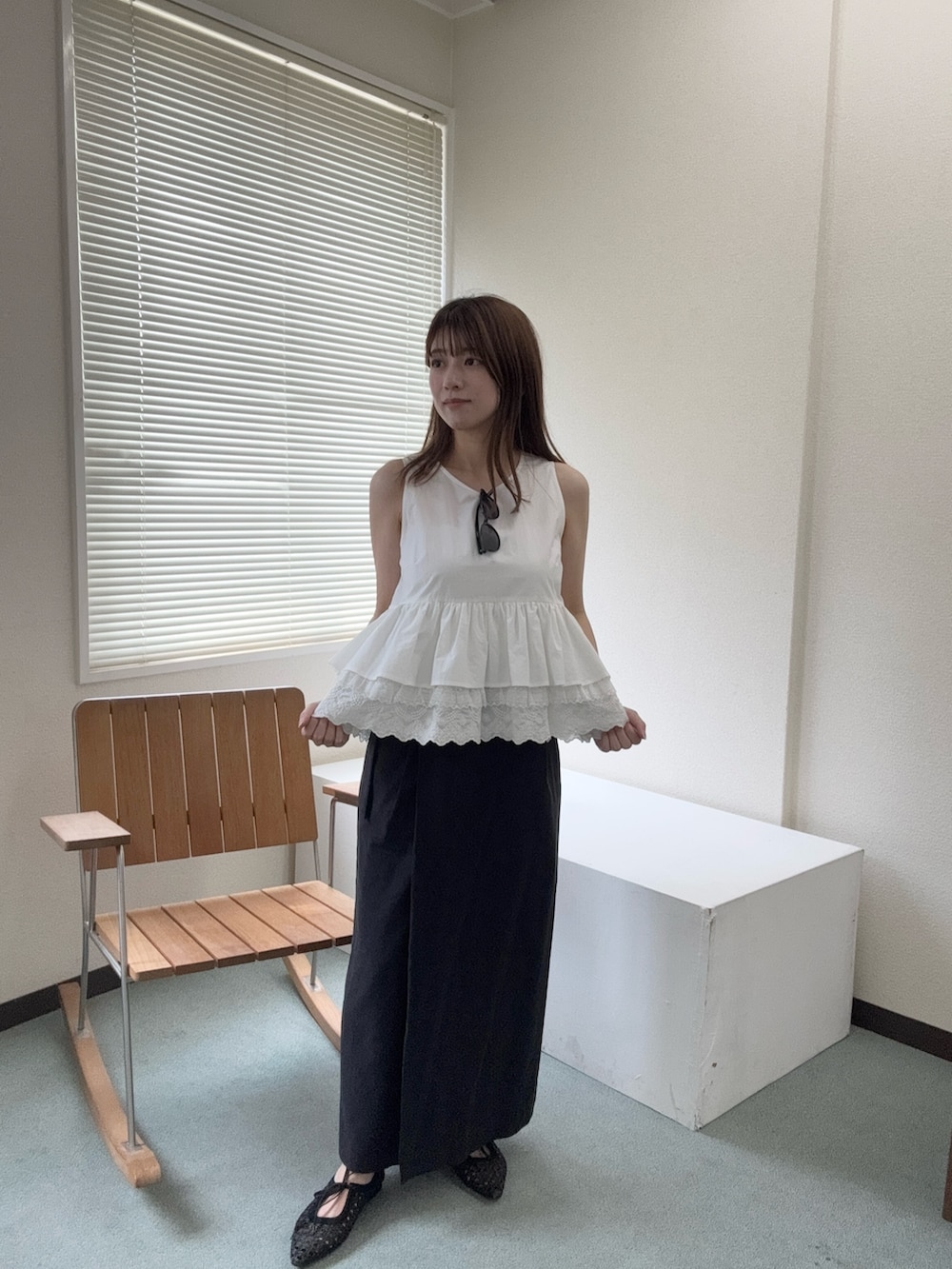 ホワイト系のシャツ/ブラウス、ブラック系のスカート、ブラック系のパンプスを着用したレディースの夏コーディネートの3枚目の写真