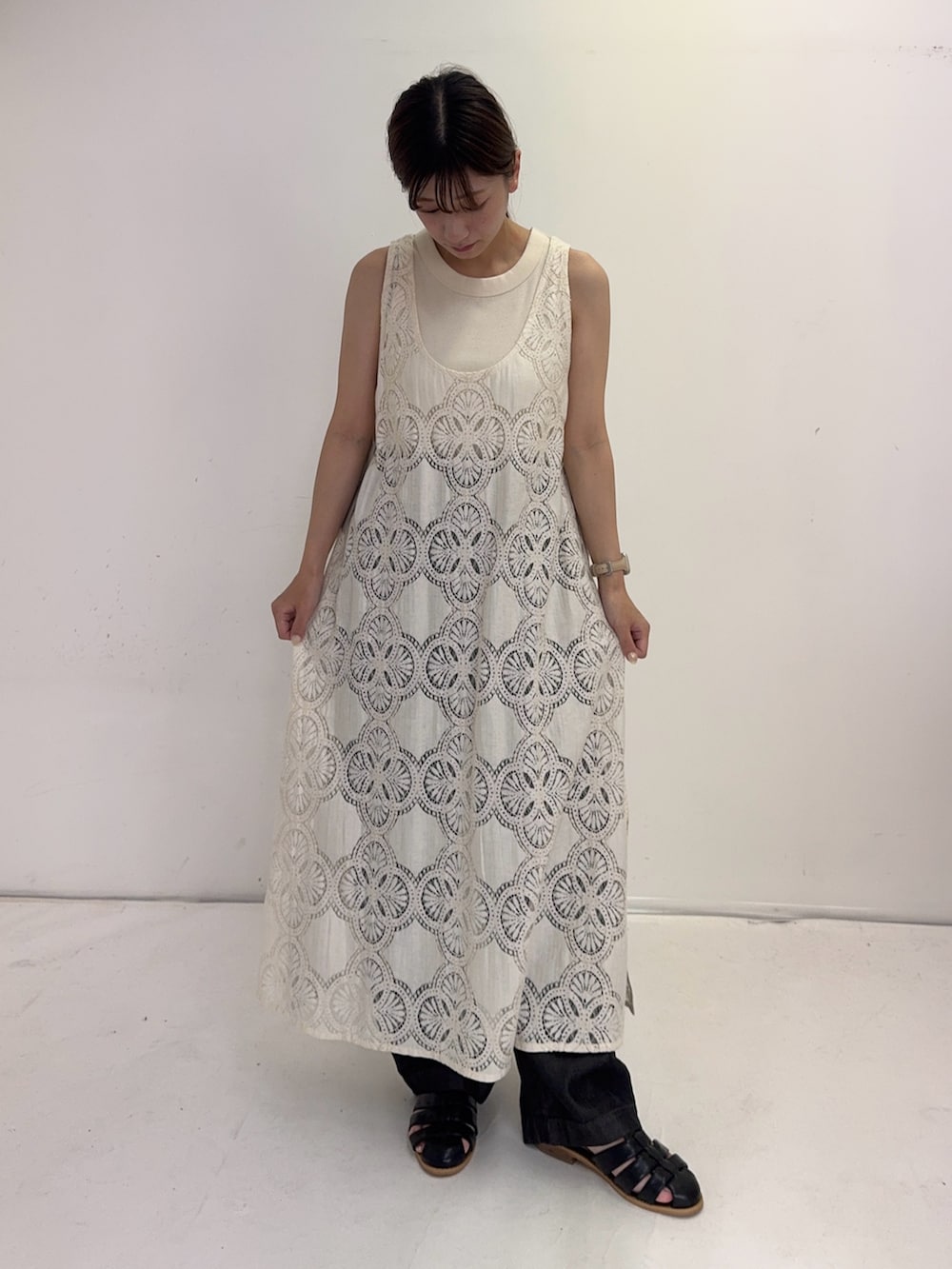 ベージュ系のワンピース、ブラック系のデニムパンツ、ブラック系のサンダルを着用したレディースの夏コーディネートの4枚目の写真