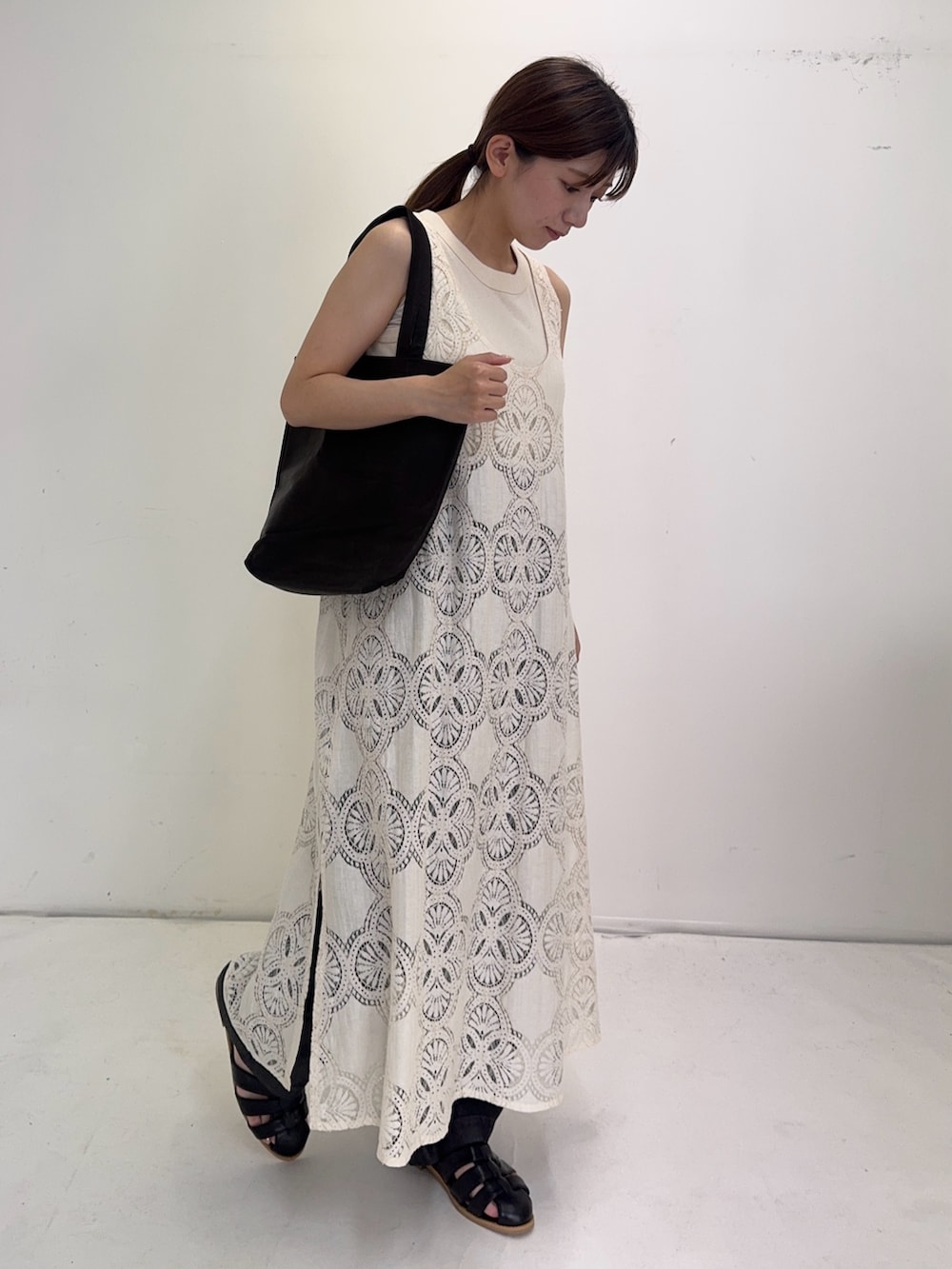 ベージュ系のワンピース、ブラック系のデニムパンツ、ブラック系のサンダルを着用したレディースの夏コーディネートの3枚目の写真