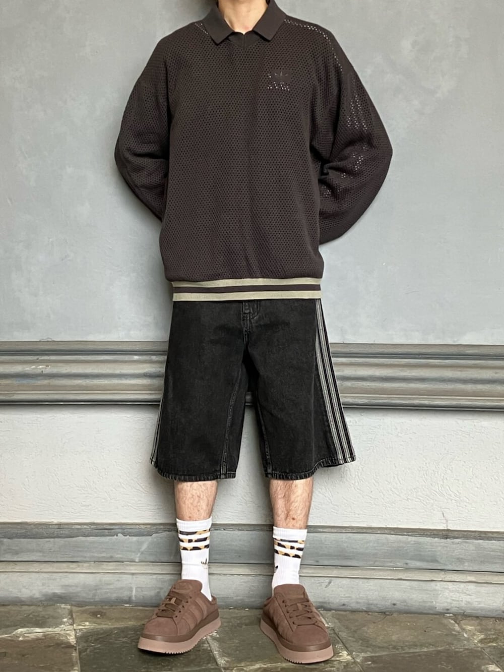 ブラック系のデニムパンツ、ブラック系のトップス、ブラウン系のスニーカーを着用したメンズの秋コーディネートの4枚目の写真