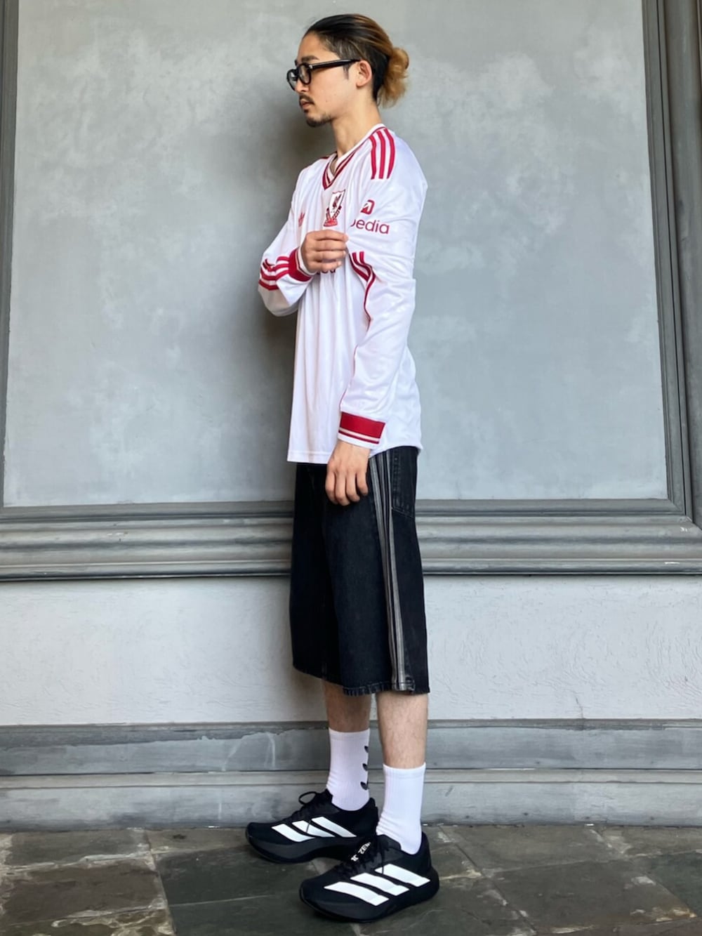 ホワイト系のTシャツ/カットソー、ブラック系のデニムパンツ、ブラック系のスニーカーを着用したメンズの夏コーディネートの2枚目の写真