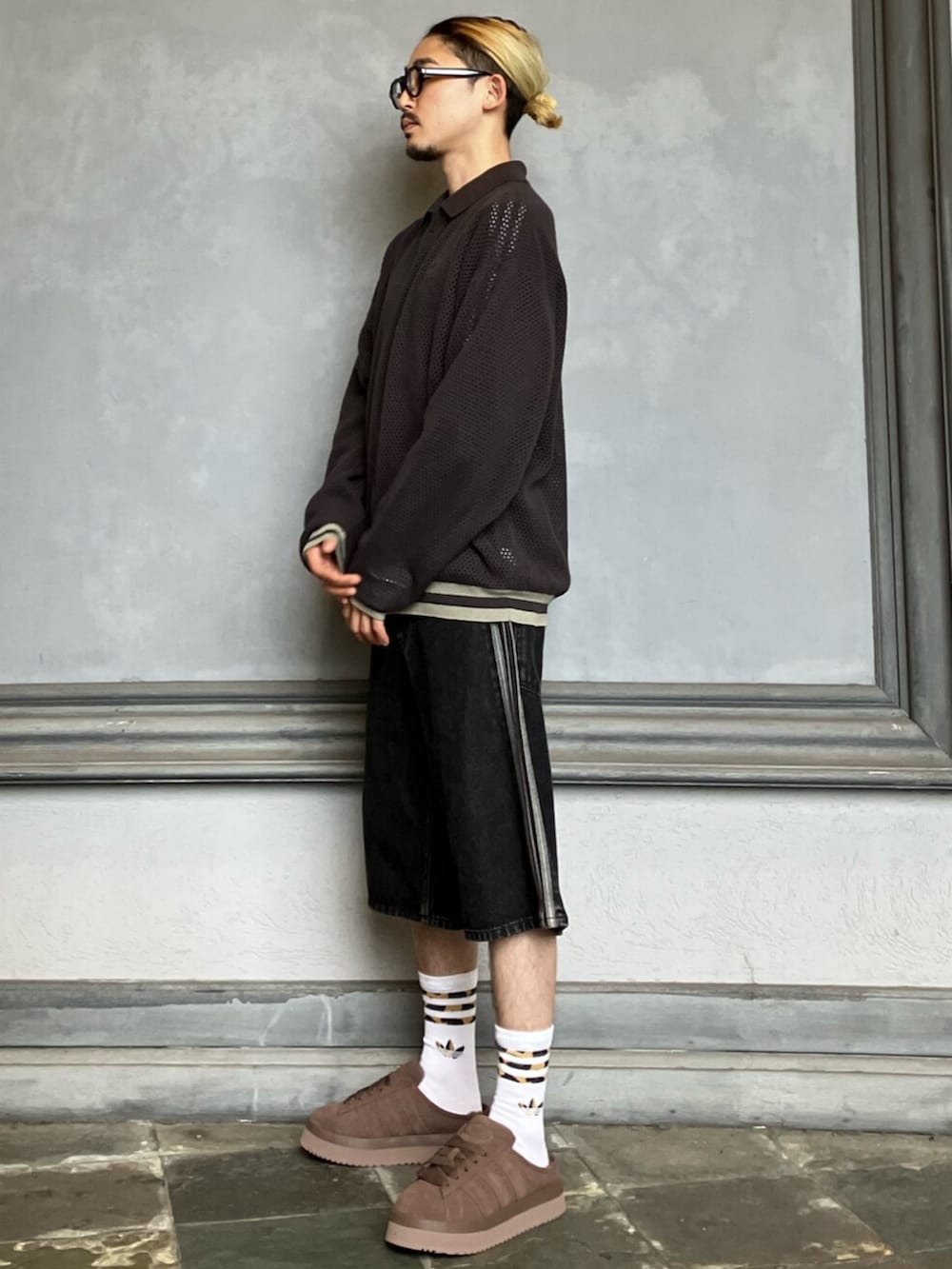 ブラック系のデニムパンツ、ブラック系のトップス、ブラウン系のスニーカーを着用したメンズの秋コーディネートの2枚目の写真