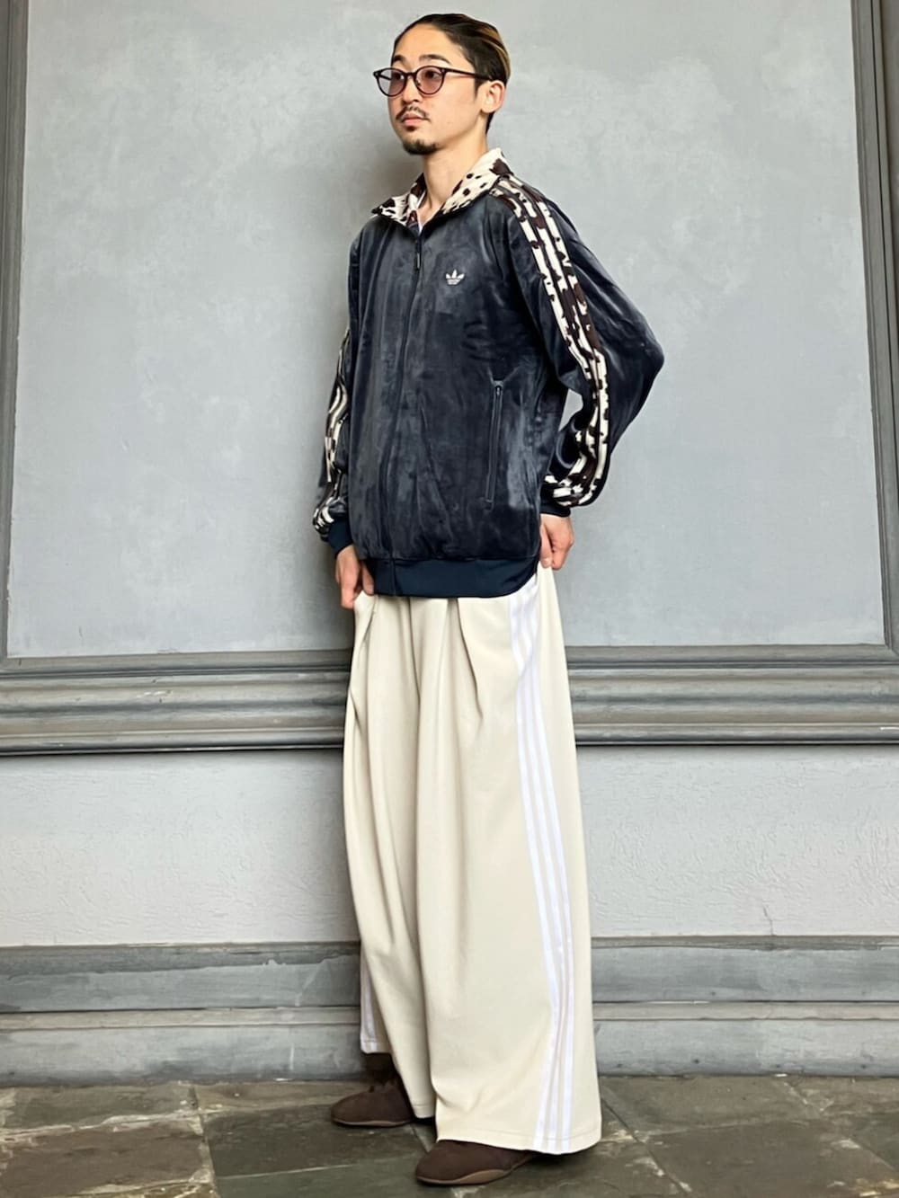 ベージュ系のスウェットパンツ、ブルー系のジャージ、ブラウン系のスニーカーを着用したメンズの秋コーディネートの2枚目の写真